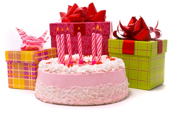 Růžový koláč se sedmi svíčkami a dary — Stock fotografie