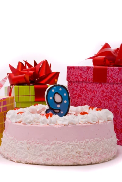 Розовый пирог со свечой и подарками в коробках — стоковое фото