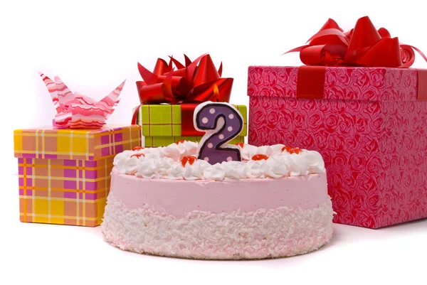 Růžový koláč s svíčku a dary v krabicích — Stock fotografie