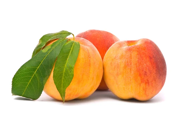 Персикові фрукти з зеленим листям — стокове фото