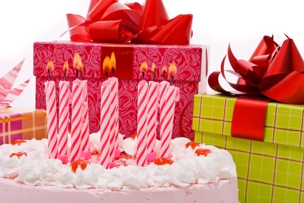 Розовый пирог со свечами и подарками — стоковое фото