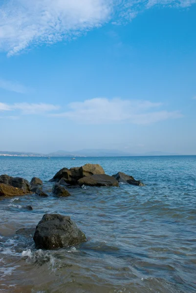Costa do mar com pedras na água — Fotografia de Stock