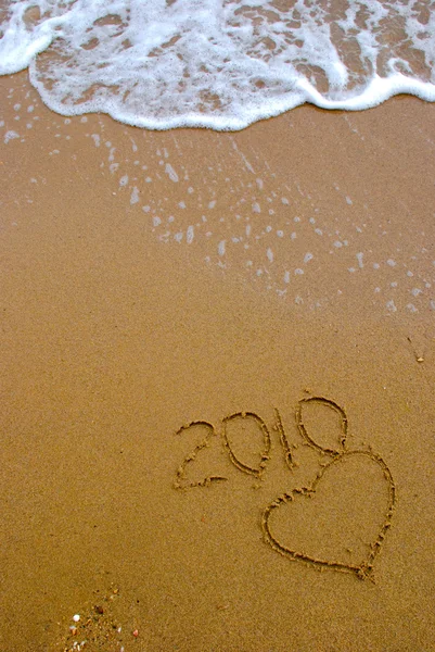 Año 2010 escrito en la arena — Foto de Stock