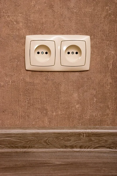 Electric socket on brown wallpaper — Stock Photo, Image