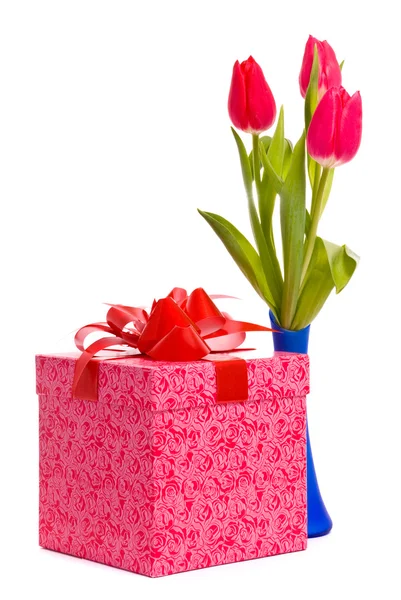 Röda tulpaner i blå vas och gift box — Stockfoto