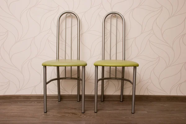 Två stolar mot en beige vägg — Stockfoto