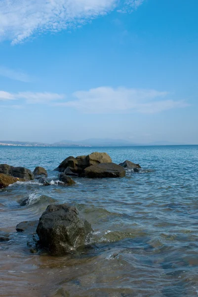 Берег моря з камінням у воді — стокове фото