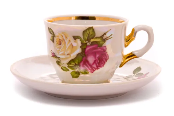 Çay fincanı ve tabağı üzerinde beyaz bir — Stok fotoğraf