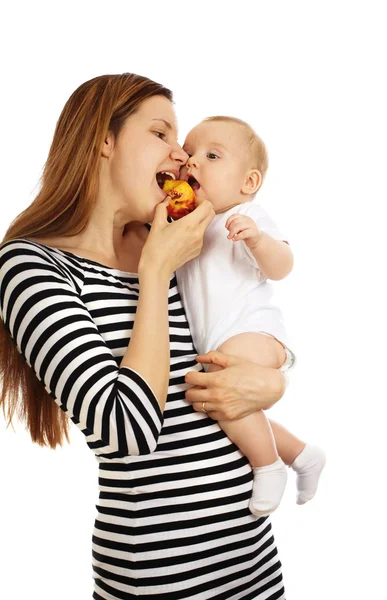 Woman and her baby eating a peach — Stock Photo, Image