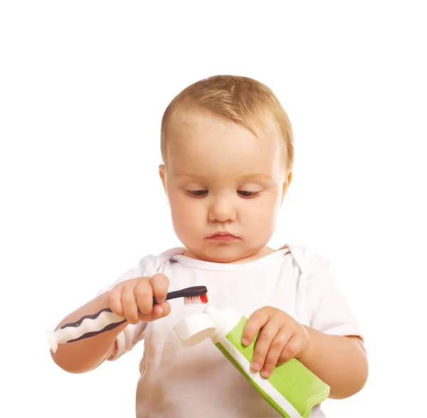 El niño con una pasta de dientes —  Fotos de Stock