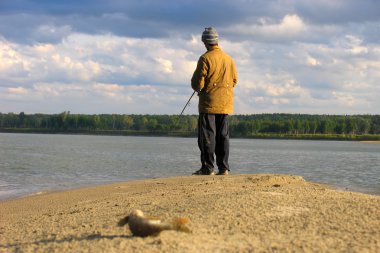 Fisherman fishes on a shallow clipart