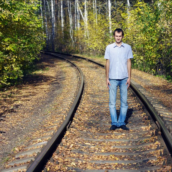 stock image The young man costs on rails