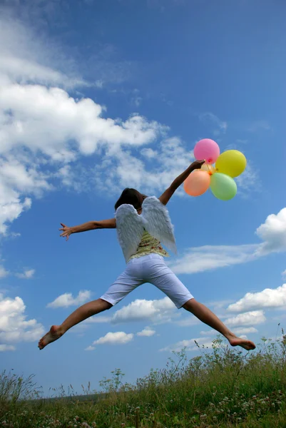 Happy woman flying with balloons — Stock Photo, Image