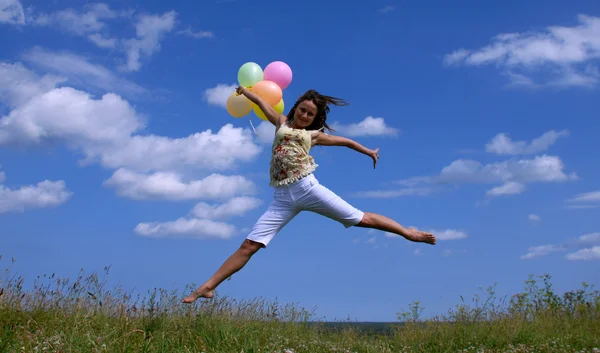 Gelukkige vrouw vliegen met ballonnen — Stockfoto