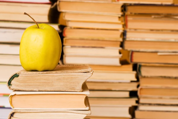 Manzana amarilla en la pila de libros — Foto de Stock