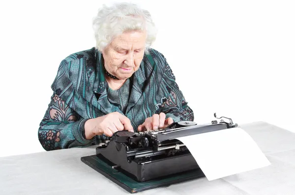 Бабуся з антикварною друкарською машинкою — стокове фото