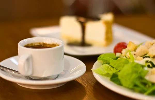 Stock image Cup of espresso with cake and salad