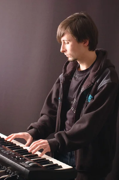 Egy fiatal ember, játszik egy szintetizátor — Stock Fotó