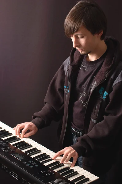 Egy fiatal ember, játszik egy szintetizátor — Stock Fotó