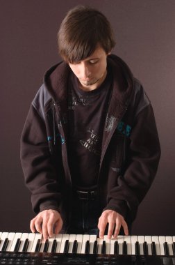 genç bir adam bir synthesizer oynarken