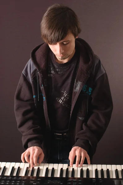 stock image A young man playing on a synthesizer