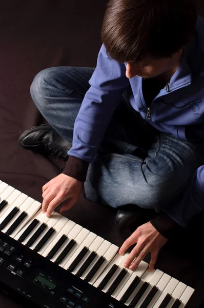 Um jovem a jogar num sintetizador — Fotografia de Stock