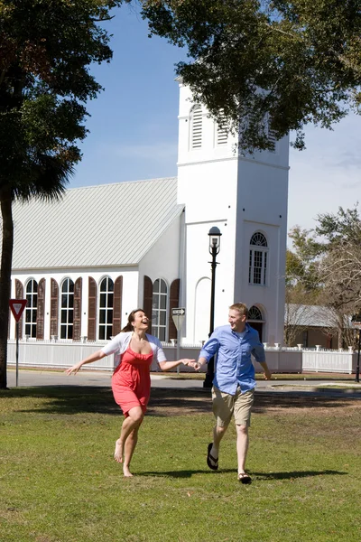 Paar läuft an Kirche vorbei — Stockfoto