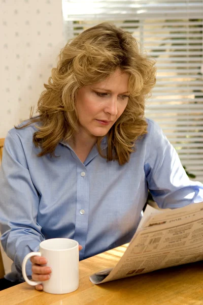 Γυναίκα ανάγνωση εφημερίδων με καφέ — Φωτογραφία Αρχείου