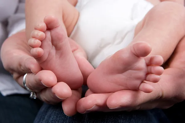 Segurando pés de bebê — Fotografia de Stock