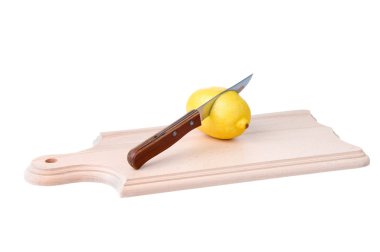 Knife pierces a lemon on wooden plank clipart