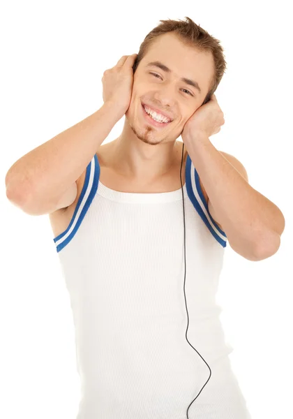 ハンサムな男の笑顔は、音楽を聴く — ストック写真