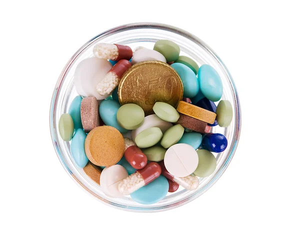 Cinquante centimes d'euro dans une soucoupe pleine de pilules — Photo
