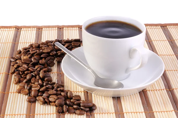 Kávová zrna a šálku s kávou — Stock fotografie