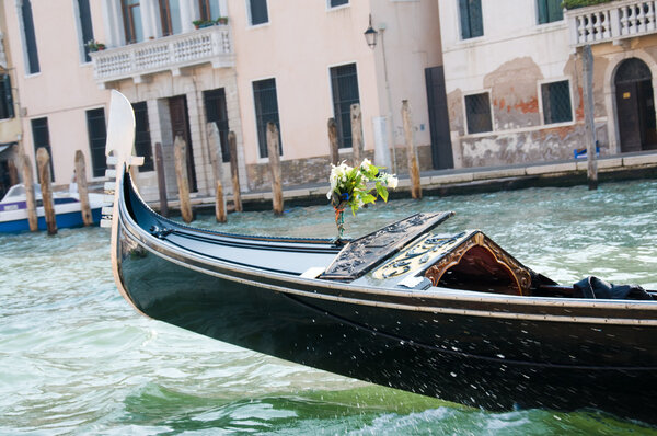 Gondola with white flowers on fore slodes on the water with drops