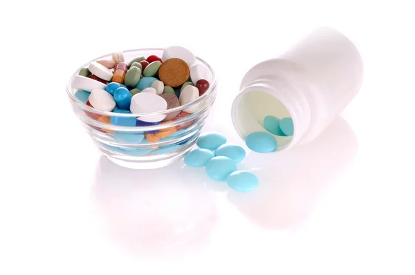 Garrafa e pires com pílulas diferentes — Fotografia de Stock