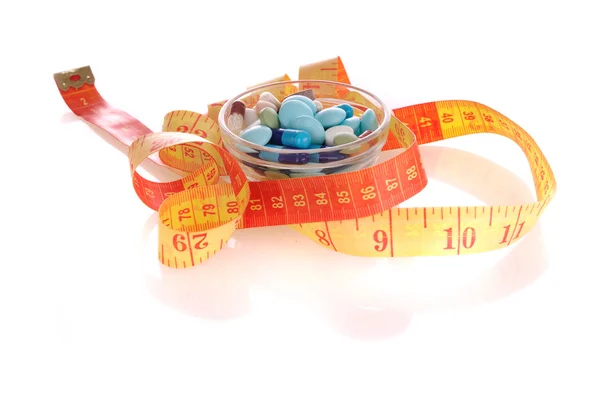 Piattino con pillole e nastro di misurazione — Foto Stock