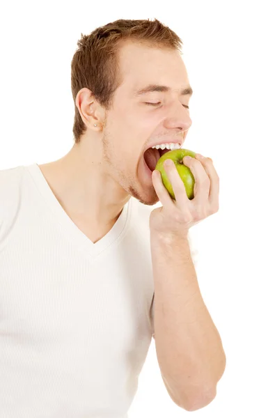 Mladý muž kouše čerstvé zelené jablko — Stock fotografie