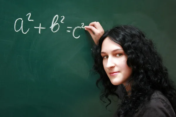 Meisje schrijven formule aan de balie — Stockfoto