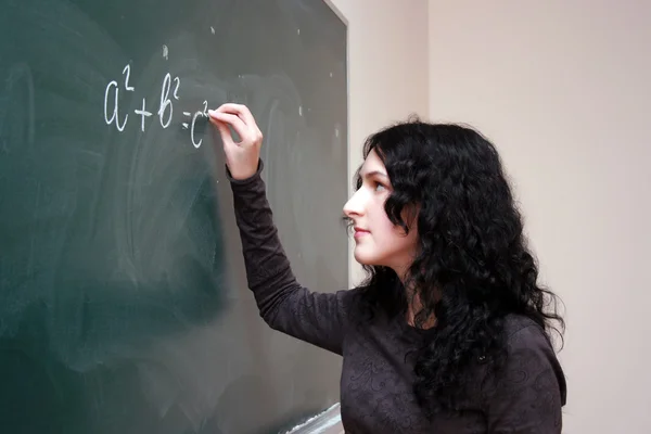 Mädchen schreibt Formel am Schreibtisch — Stockfoto