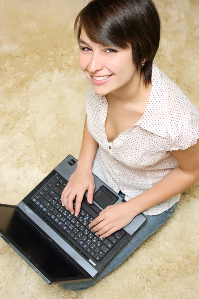 Усміхнена дівчина на темному волоссі з ноутбуком — стокове фото