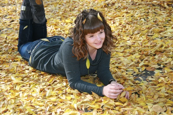 美丽的女孩在秋天的树叶 — 图库照片