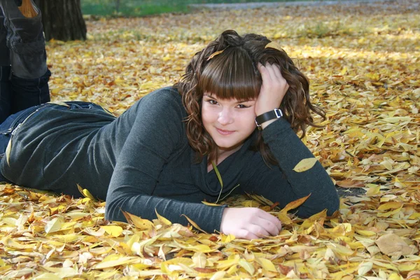 Mooi meisje in herfst bladeren — Stockfoto