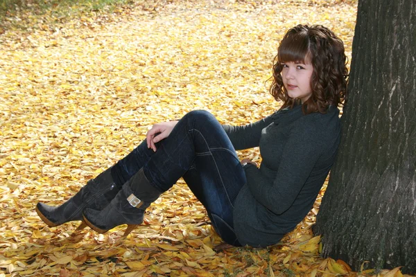 Menina bonita em folhas de outono — Fotografia de Stock