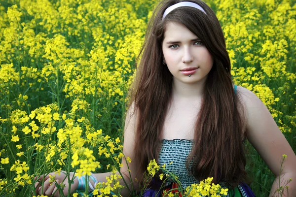 Jong meisje in canola veld — Stockfoto