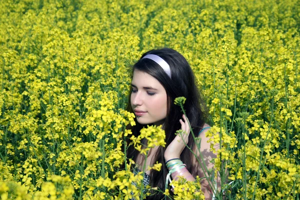 Jong meisje in canola veld — Stockfoto