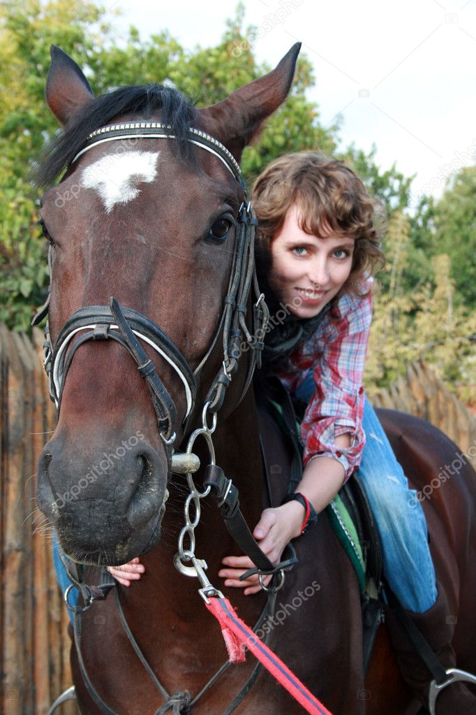 Smiling young woman on the horse