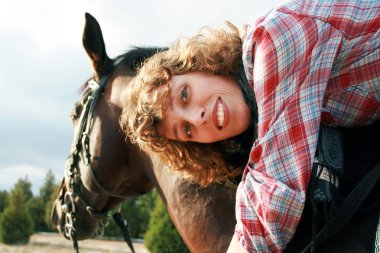 Smiling girl on her horse clipart