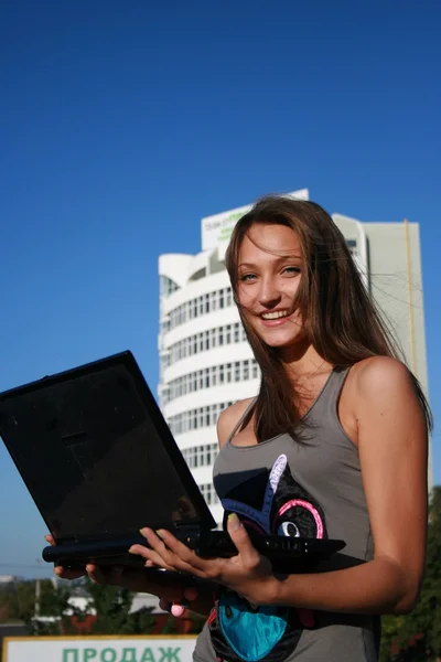 Dizüstü bilgisayar ile mutlu gülümseyen kız — Stok fotoğraf