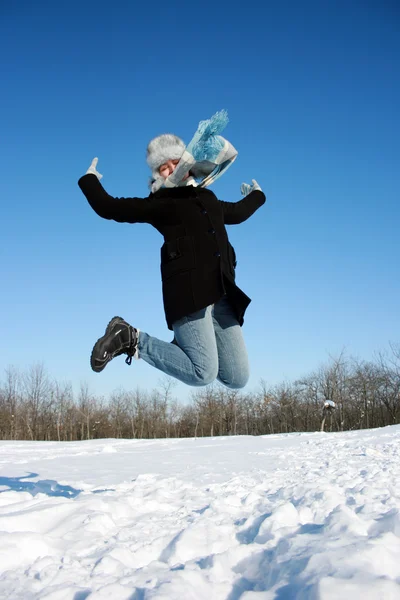 Glücklich springende Frau im verschneiten Wald — Stockfoto