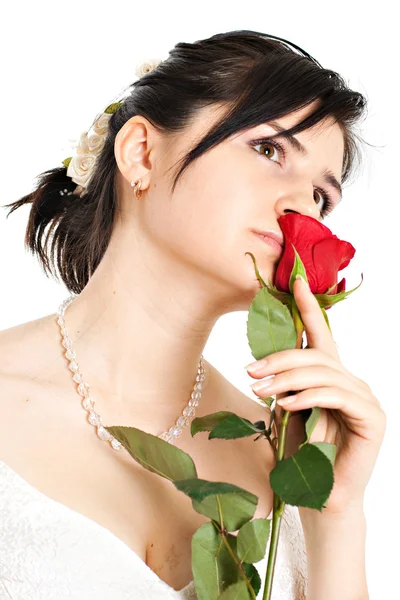 Braut schnuppert an einer roten Rose — Stockfoto